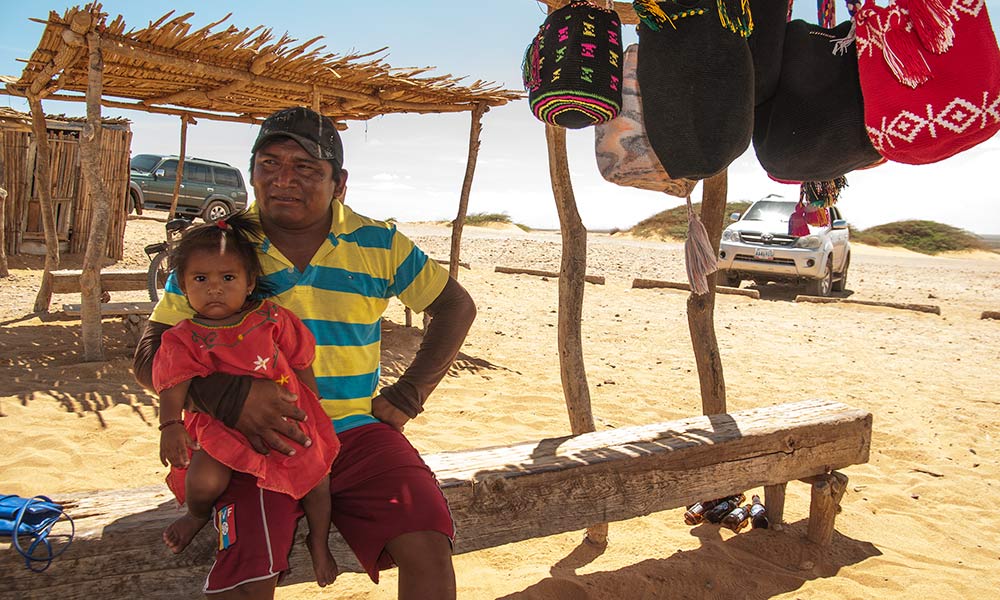 A Wayuu vendor with his child in Cabo de la Vela, Playa Dorada